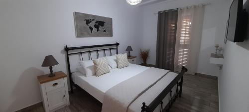 金尼昂Alisachni的一间卧室配有带白色床单和枕头的床。