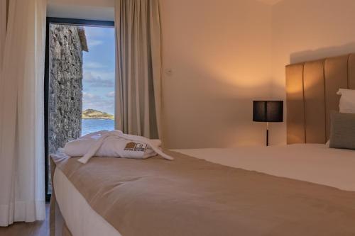 Praia da GraciosaPortas do Ilhéu的酒店客房,设有一张床铺,享有海景