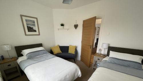 纽里Clanrye House Guest Accommodation的一间卧室配有两张床和椅子