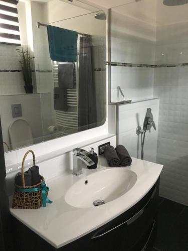陶波尔曹Petra Apartman的浴室设有白色水槽和镜子