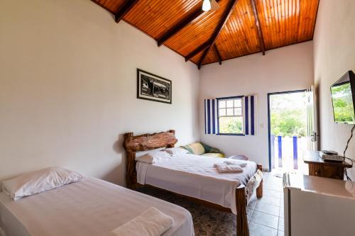 戈亚斯州科伦巴Hotel Fazenda Serra da Irara的一间卧室设有两张床和木制天花板
