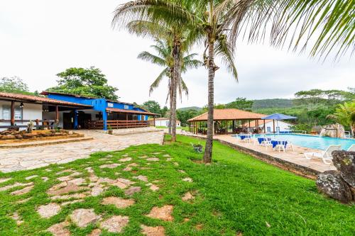 戈亚斯州科伦巴Hotel Fazenda Serra da Irara的一个带游泳池和棕榈树的度假村