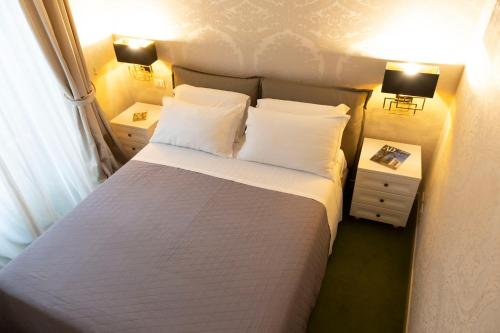 罗马Cathy's Luxury Home的一间卧室配有一张带2个床头柜和2盏灯的床。