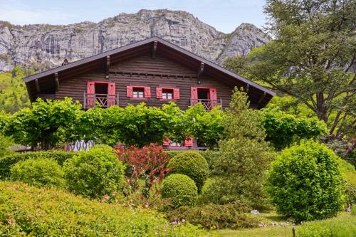 维里尔·杜·拉克Magnificent chalet on the heights of Veyrier-du-Lac - Welkeys的一座带红色窗户和山脉的木屋