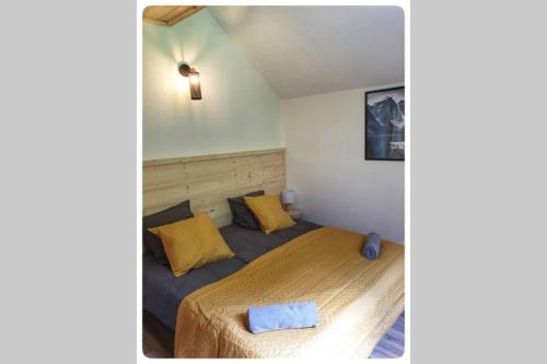 Grandes SablesCharmante Maison La Source的一间卧室配有一张带黄色枕头的床