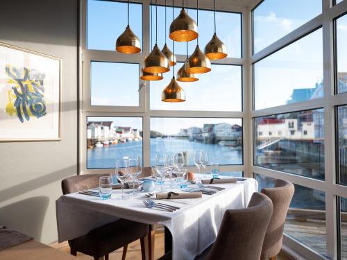 亨宁斯韦尔Villa Bryggekanten - by Classic Norway Hotels的一间带桌子和大窗户的用餐室