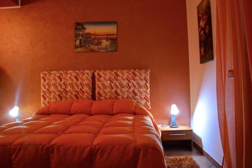 卡普多兰多A due passi dal mare的一间卧室配有一张带橙色墙壁的床和两盏灯。