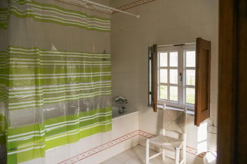 维拉诺瓦-德法马利Quinta de Pindela - Natureza e Tradicao的浴室设有绿色和白色的淋浴帘