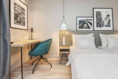考纳斯Radisson Hotel Kaunas的一间卧室配有两张床、一张桌子和一把椅子