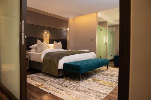 埃祖尔韦尼欢乐谷酒店及赌场的酒店客房,设有床铺和绿色长凳