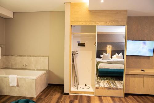 埃祖尔韦尼欢乐谷酒店及赌场的带浴缸、床和电视的浴室
