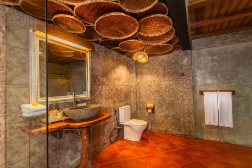 德格拉朗Sacred Valley by Pramana Villas的一间带水槽、卫生间和镜子的浴室