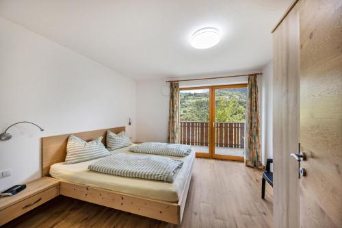 科尔皮缇亚Tschafon Oberparnaihof的一间卧室设有一张床和一个窗口