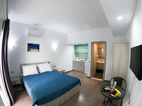 阿彻奇洛斯Red Hibiscus Stegna的一间设有蓝色床和厨房的小卧室
