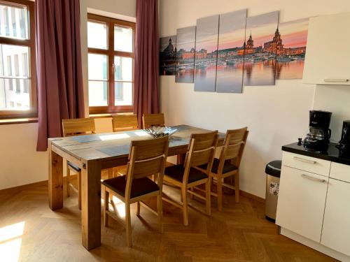 德累斯顿Familienapartment An der Frauenkirche的厨房以及带木桌和椅子的用餐室。