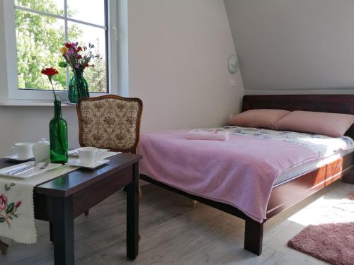 乌斯特卡Pokoje Alicja Ustka的一间卧室配有一张床、一张桌子和一个窗户。