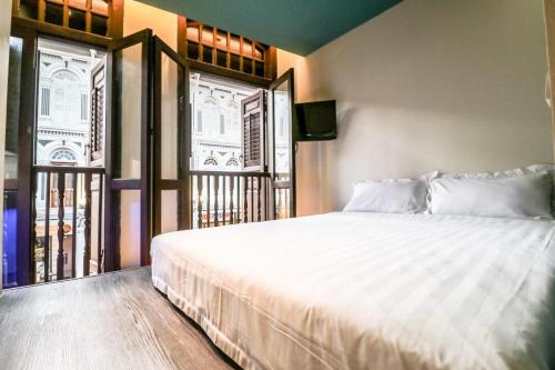 新加坡Hotel Calmo Chinatown的卧室设有一张白色大床和一扇窗户。