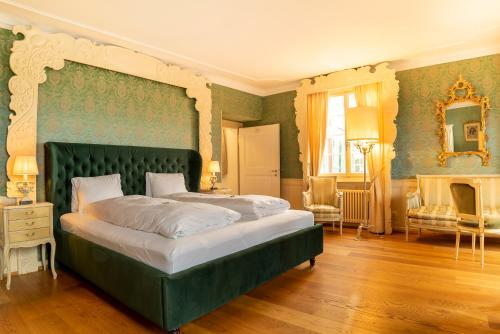 戈特利本Hotel Porto Sofie Gottlieben的一间卧室配有一张大床和绿色床头板