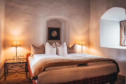 蒂罗尔州霍尔英格兰金色酒店的一间卧室配有一张大床和两盏灯