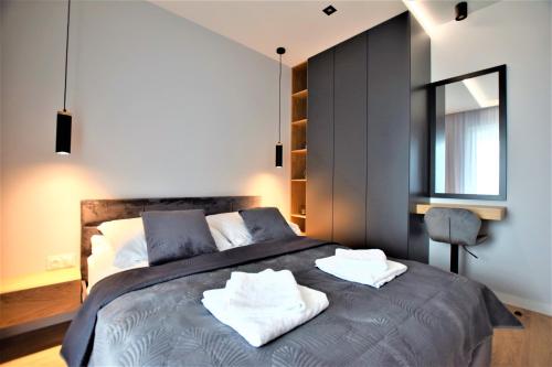 热舒夫Premium Apartments Rzeszów的一间卧室配有一张床,上面有两条毛巾