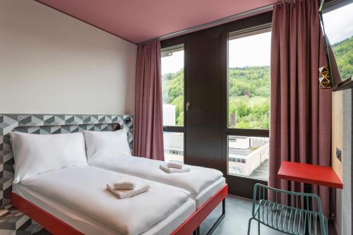 苏黎世MEININGER Hotel Zürich Greencity的一间卧室设有一张床和一个大窗户