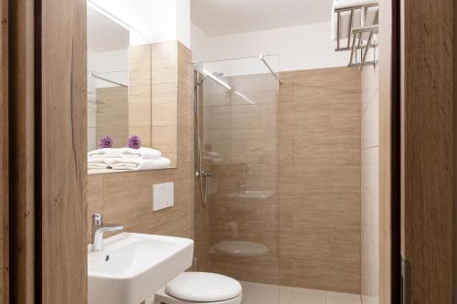帕德博恩Dominik Hotel & Eventsaal的带淋浴、卫生间和盥洗盆的浴室