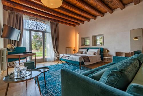 维罗纳Relais Villa dei Gelsi & Spa的客厅配有蓝色的沙发和床。