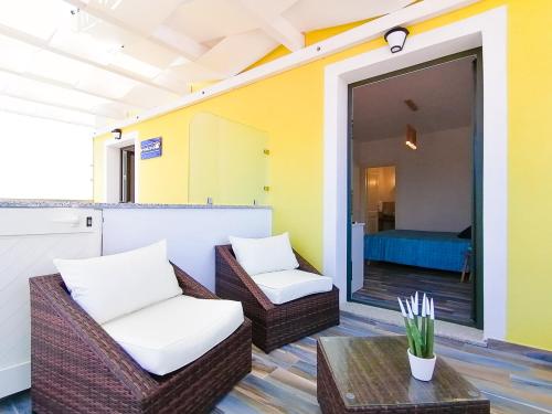 圣特雷莎加卢拉B&B La Torre Elite的一个带藤椅和桌子的庭院和一间卧室