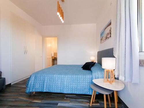 圣特雷莎加卢拉B&B La Torre Elite的一间卧室配有蓝色的床和一张桌子及两把椅子