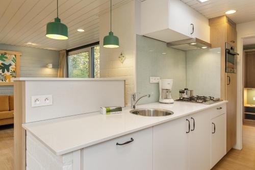 佩尔Center Parcs Erperheide的厨房配有白色橱柜和水槽
