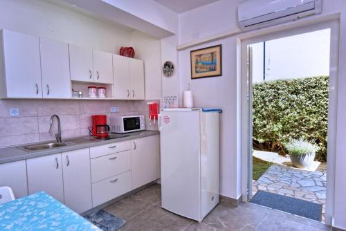 克尔克Apartment Gerber Krk的厨房配有白色橱柜和冰箱。