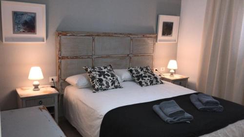 塞博河畔卡莱塔Apartamentos Burgao的一间卧室配有一张带枕头的床和两盏灯。