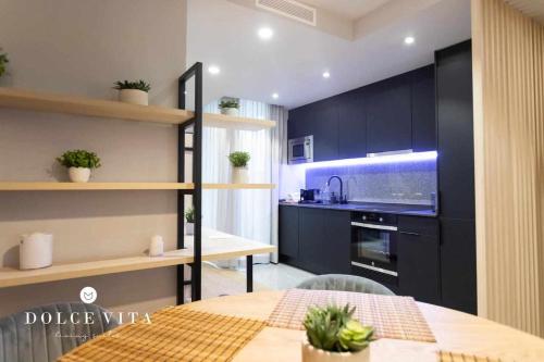 比亚雷亚尔Apartamento Napoli living suites en Vila real的一间厨房,内设黑色橱柜和一张桌子