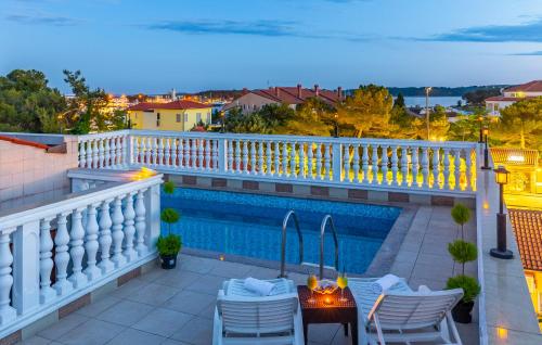 梅杜林Villa San Rocco Bed & Breakfast的一个带桌椅的阳台和一个游泳池