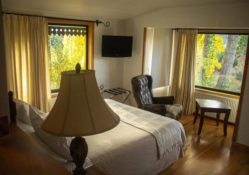 科伊艾科El Reloj Hotel的卧室配有床、椅子和窗户。