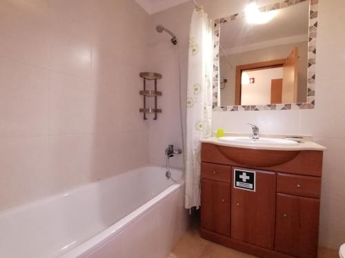 波尔蒂芒Encosta da Marina Beach Apartment的带浴缸、水槽和镜子的浴室