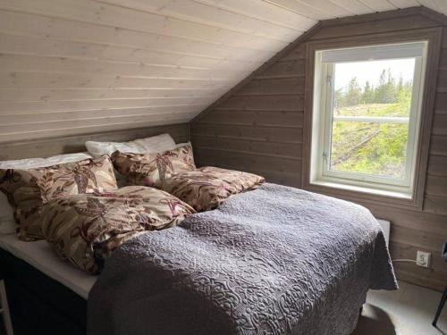 伯Ski in-out at Lifjell-Mountain cabin with majestic views close to Bø Sommarand的窗户客房内的一张床位