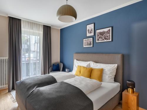 巴德加斯坦Das Schider - Boutique Apart-Hotel的一间卧室设有两张带蓝色墙壁的床