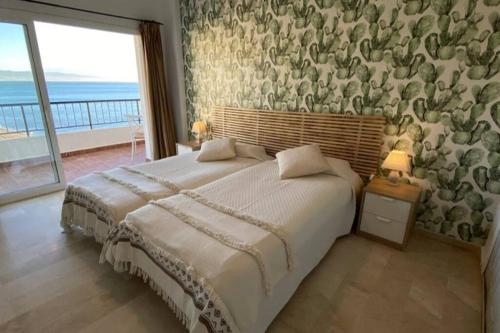 多列毛利诺斯Amazing frontline sea views Studio apartment Castillo Del Vigia Torremolinos的一间卧室设有一张大床,享有海景