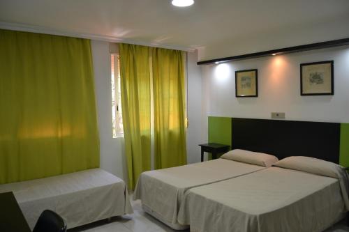 拉利内阿-德拉康塞普西翁米拉玛酒店的一间卧室设有两张床和绿色窗帘