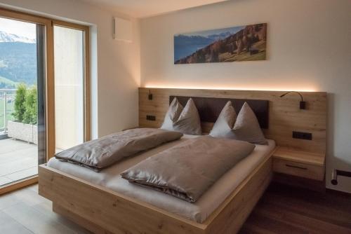 MaretaJaufnerhof的一间卧室设有一张木床和大窗户