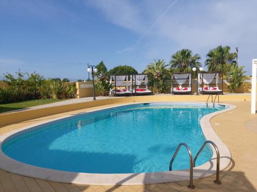 卡武埃鲁Quinta Nova Vale Del Rey的周围设有大型游泳池,配有椅子