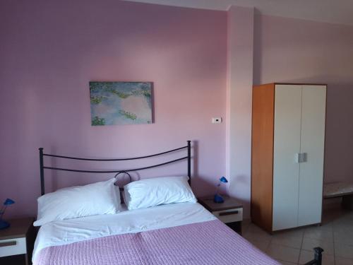 佩斯卡拉Mansarda Gardenia的一间卧室配有一张粉红色墙壁的床