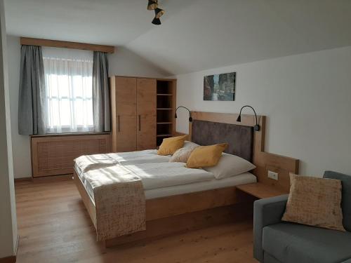 萨尔茨堡Apartments by Pension Ballwein的一间卧室配有一张大床和一张沙发