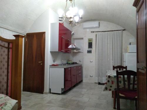 莫托拉Casa Charme Rotonda的厨房配有红色橱柜和白色冰箱