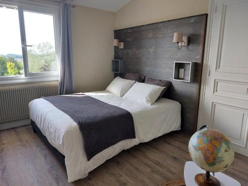 MontaiguLe relais globe trotteur的一间卧室配有一张大床和木制床头板