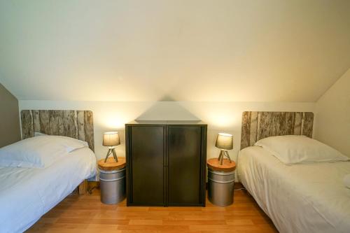 日耶Les Aravis - Apartment for 6 people 5min from the lake的一间卧室设有两张床,墙上有两盏灯。