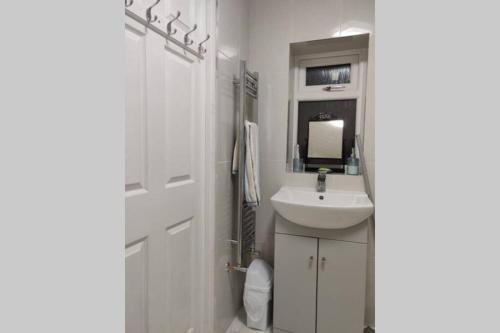 伯明翰Luxury apartment in Birmingham with free parking.的白色的浴室设有水槽和镜子