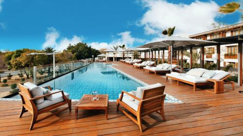 普埃布拉Cartesiano Boutique & Wellness Hotel的一个带躺椅和遮阳伞的游泳池