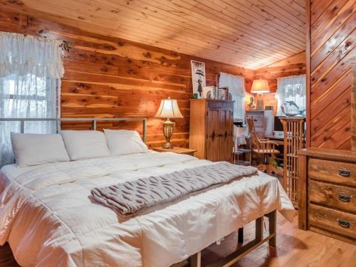 ComptonFly Away Cabin- Modern, Serene, And Convenient的卧室配有一张床铺,位于带木墙的房间内